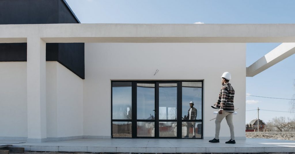 Architect with hard hat evaluating modern house exterior. Ideal for construction and architecture themes.